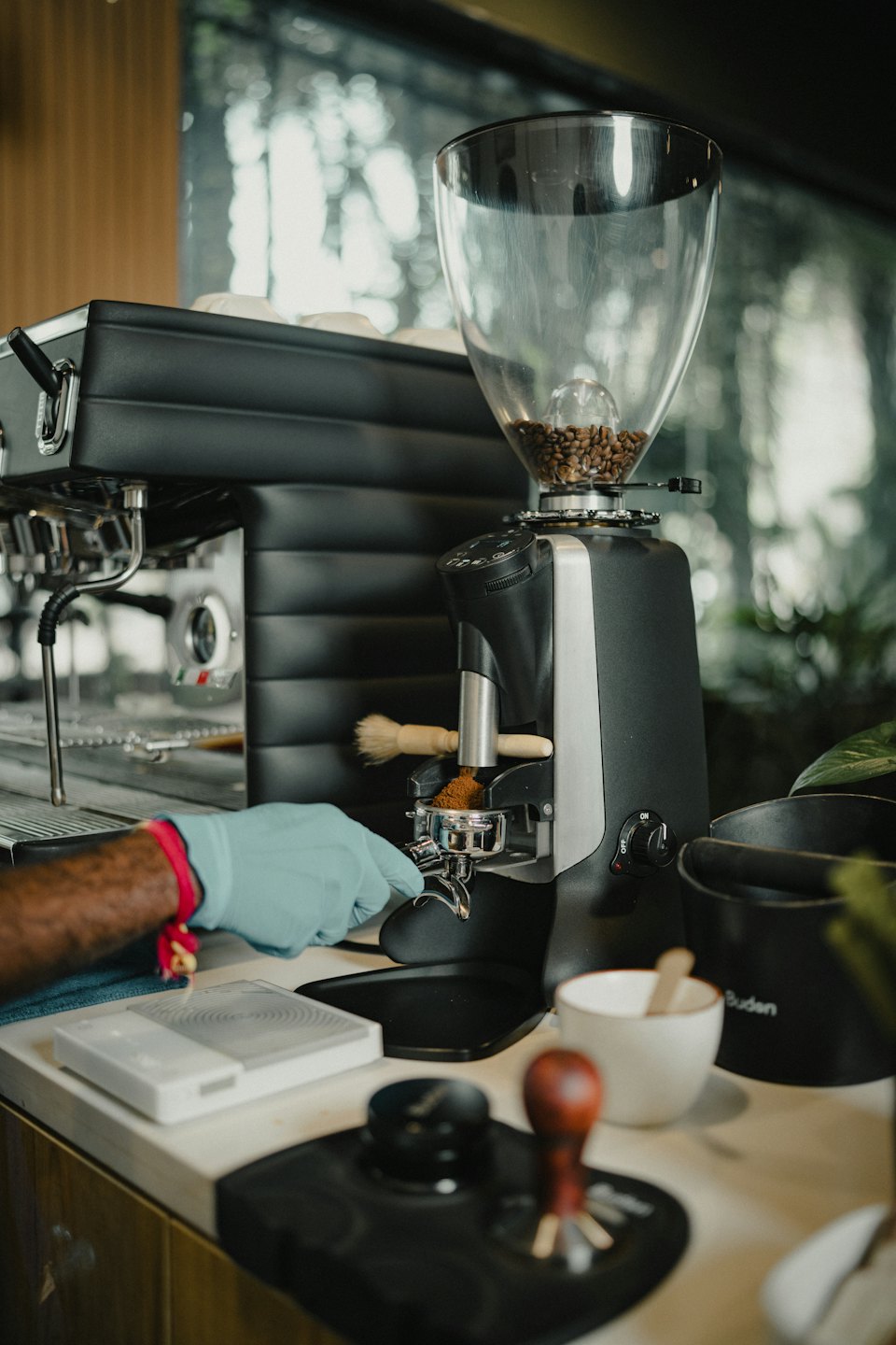 A barista grinds coffee beans into a portafilter.